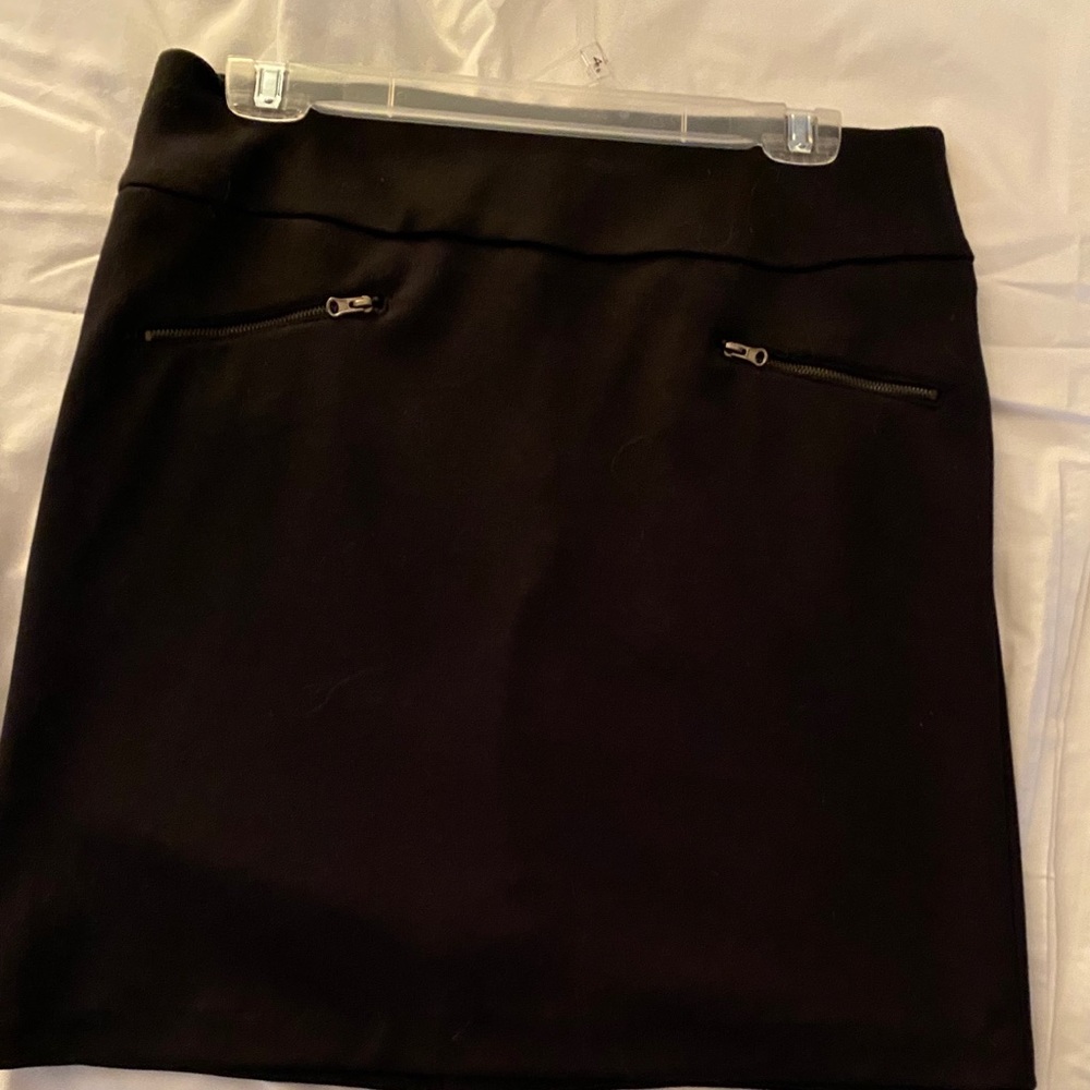 Black skirt. Just above knee. Zippers in front.